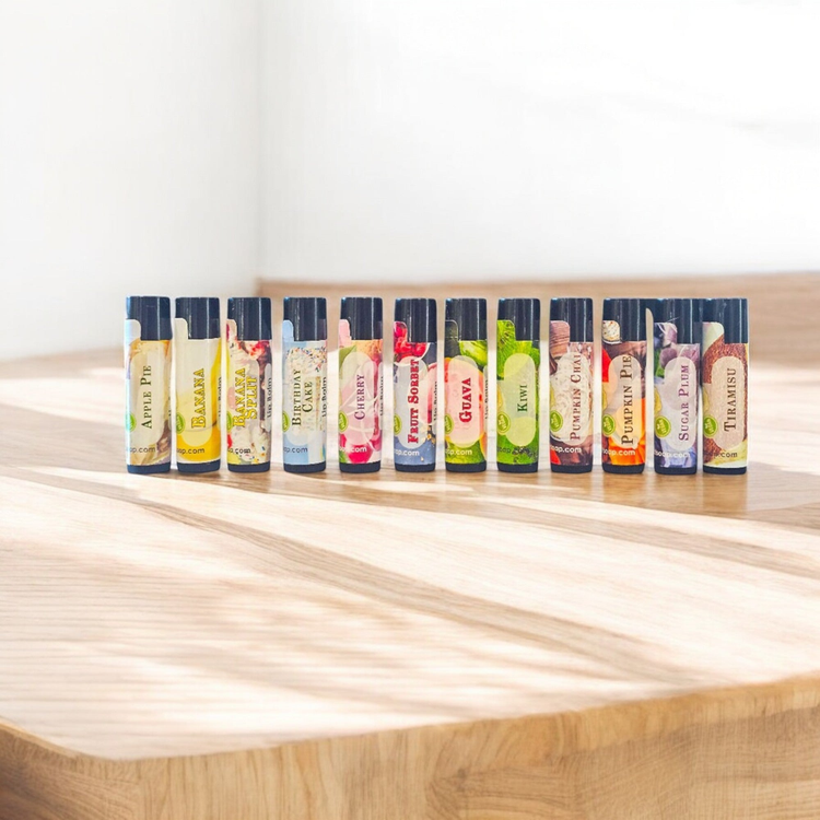 Lip Balm in a variety of flavors shown in a group on a wood countertop